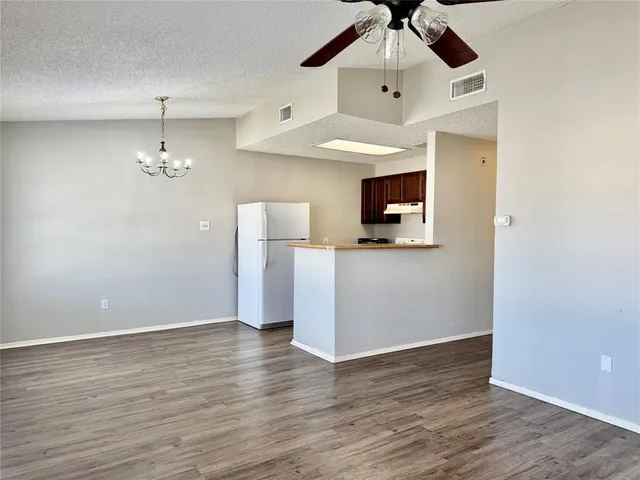 a view of a room with wooden floor ceiling fan and window