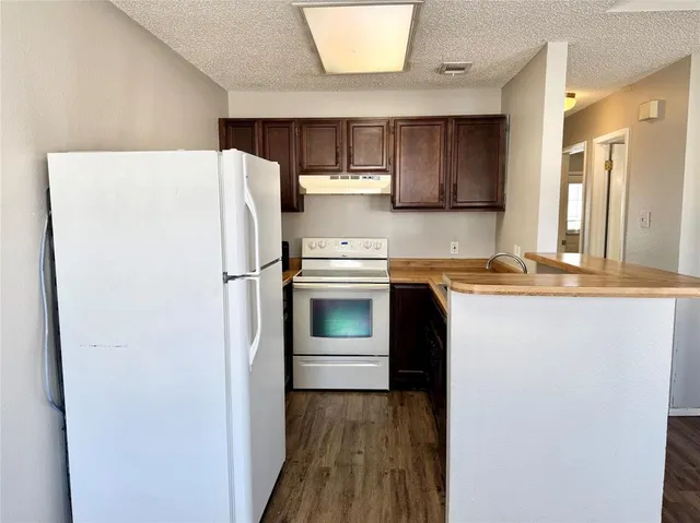 a kitchen with a refrigerator and a stove top oven