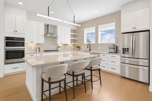 a kitchen with white cabinets and stainless steel appliances