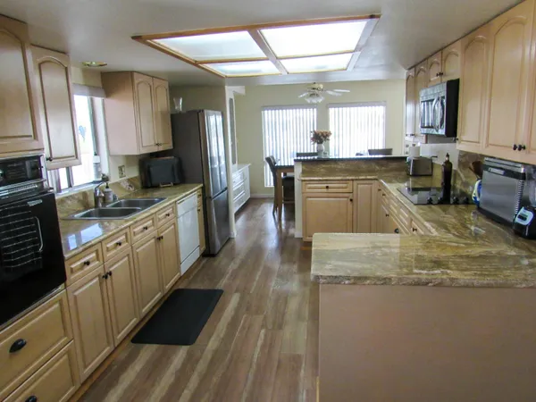 a kitchen with stainless steel appliances granite countertop a sink stove and refrigerator