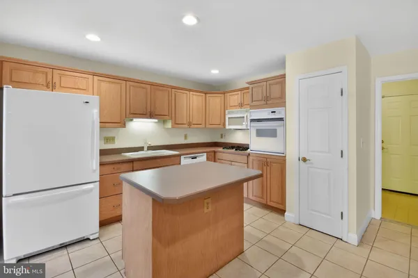 a kitchen with a refrigerator a stove top oven and cabinets