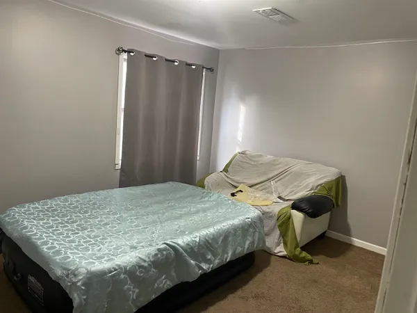 a bedroom with a bed and a window