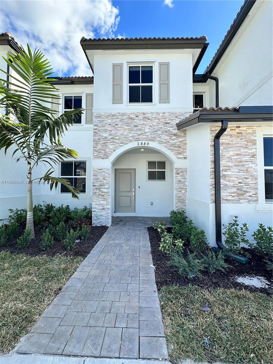 2889 Southeast 25rd, Unit 2889 Homestead, FL 33035 - Photo 1 of 23 a front view of a house with a yard and garage