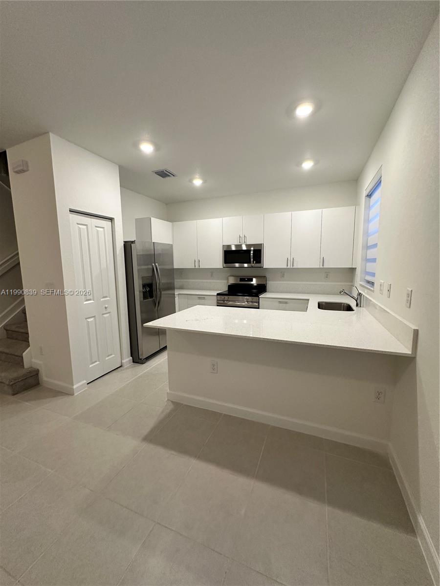 2889 Southeast 25rd, Unit 2889 Homestead, FL 33035 - Photo 13 of 23 a view of kitchen with stainless steel appliances refrigerator stove microwave and sink