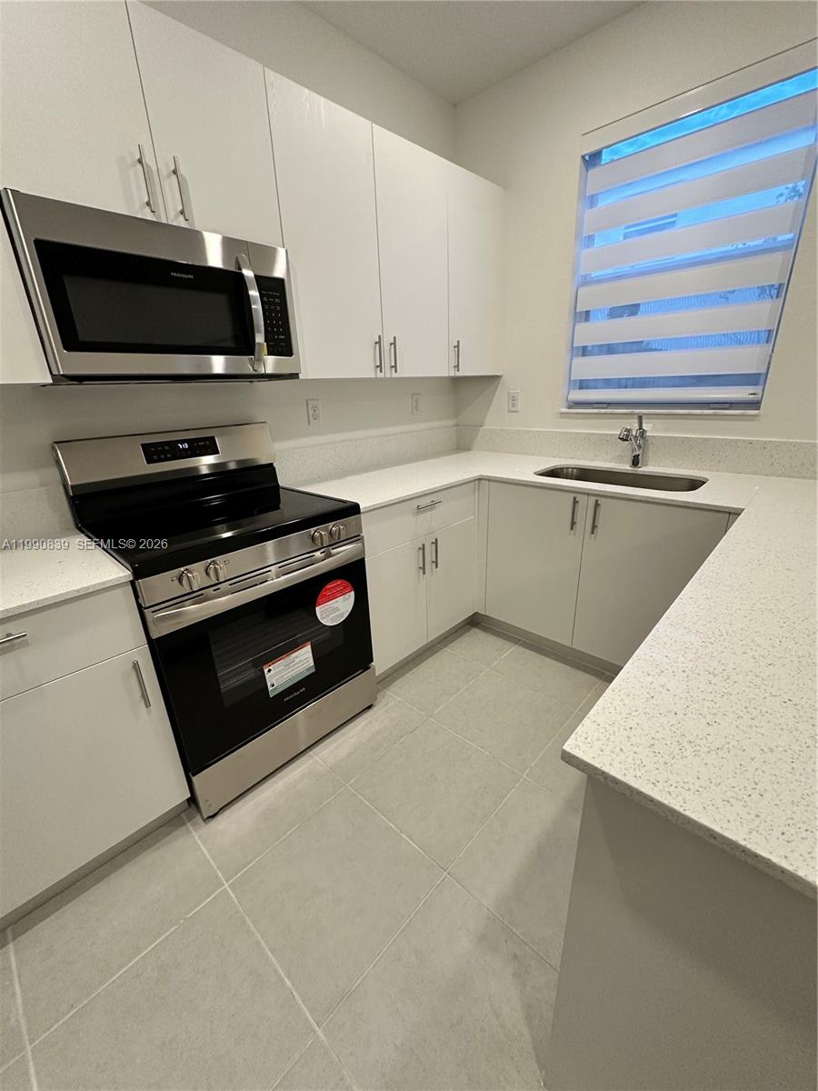 2889 Southeast 25rd, Unit 2889 Homestead, FL 33035 - Photo 2 of 23 a kitchen with a sink and a stove top oven