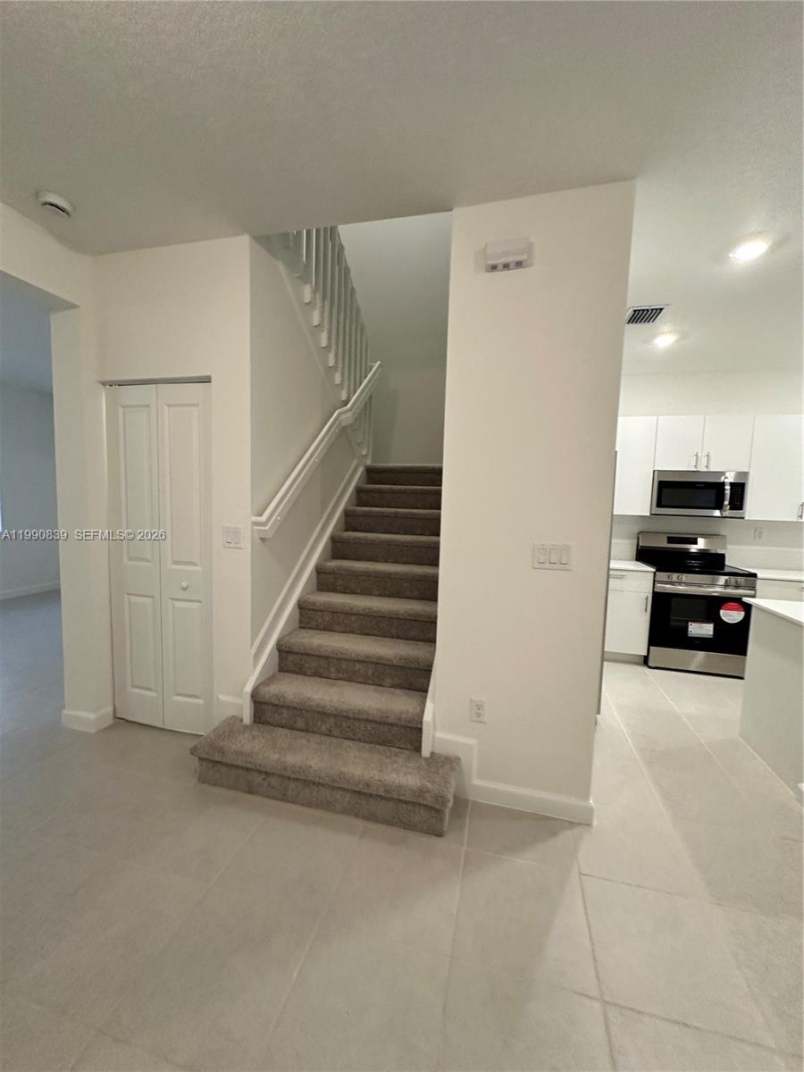 2889 Southeast 25rd, Unit 2889 Homestead, FL 33035 - Photo 22 of 23 a view of a livingroom with a flesh screen tv and stairs