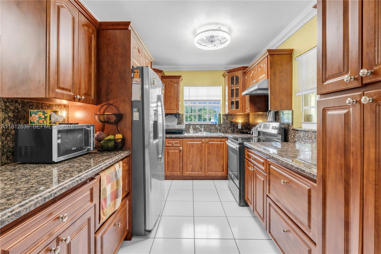 18820 Southwest 316th Street Homestead, FL 33030 - Photo 6 of 43 a kitchen with stainless steel appliances granite countertop a stove a sink and a microwave