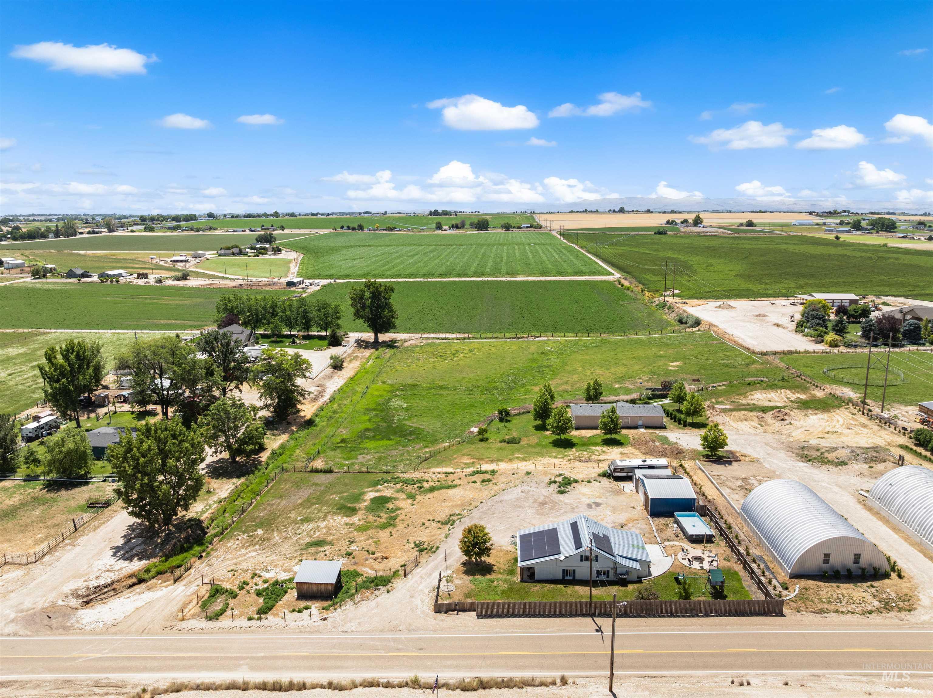 17441 Upper Pleasant Ridge Road Caldwell, ID 83607 - Photo 35 of 40 Expansive property featuring a residence with solar panels, multiple outbuildings, and a large metal Quonset hut