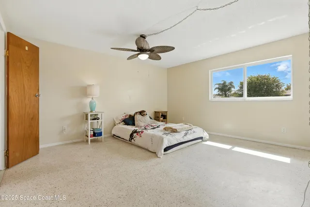 a bed room with a bed and a ceiling fan