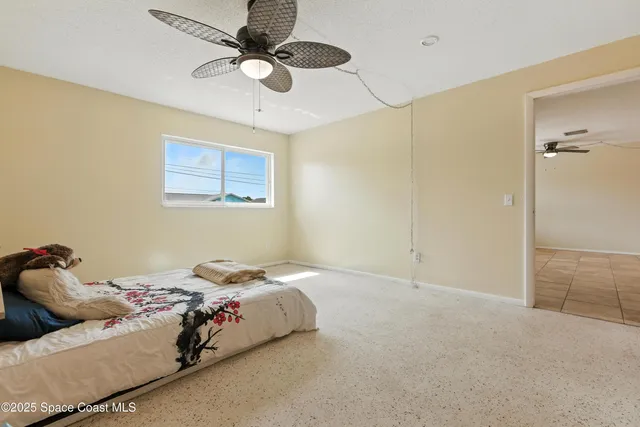 a bedroom with a bed and a ceiling fan