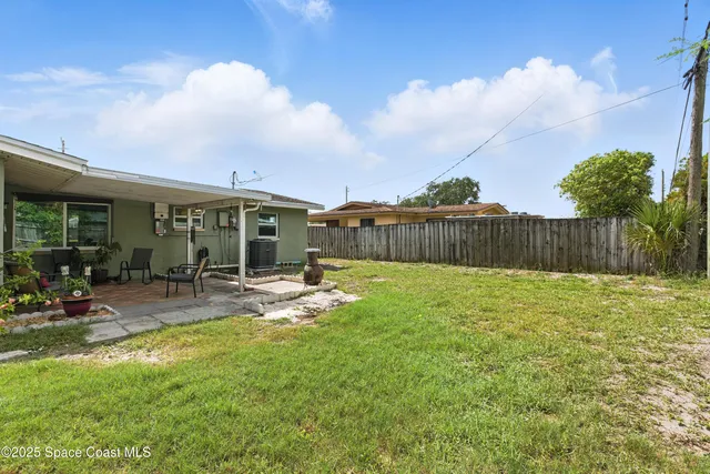 a view of a backyard with sitting area and garden