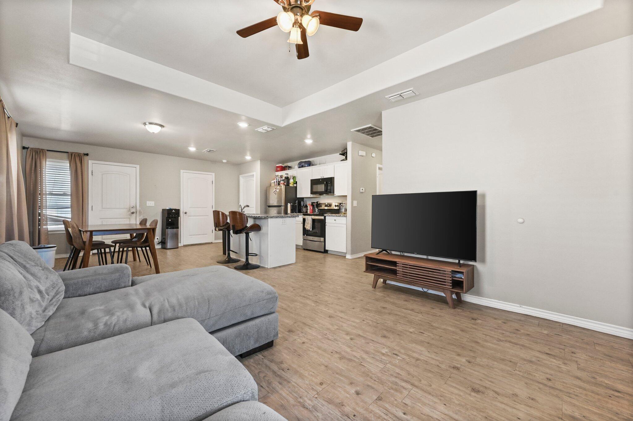 2116 24th Street, Unit 1 Lubbock, TX 79411 - Photo 3 of 13 a living room with furniture and a flat screen tv