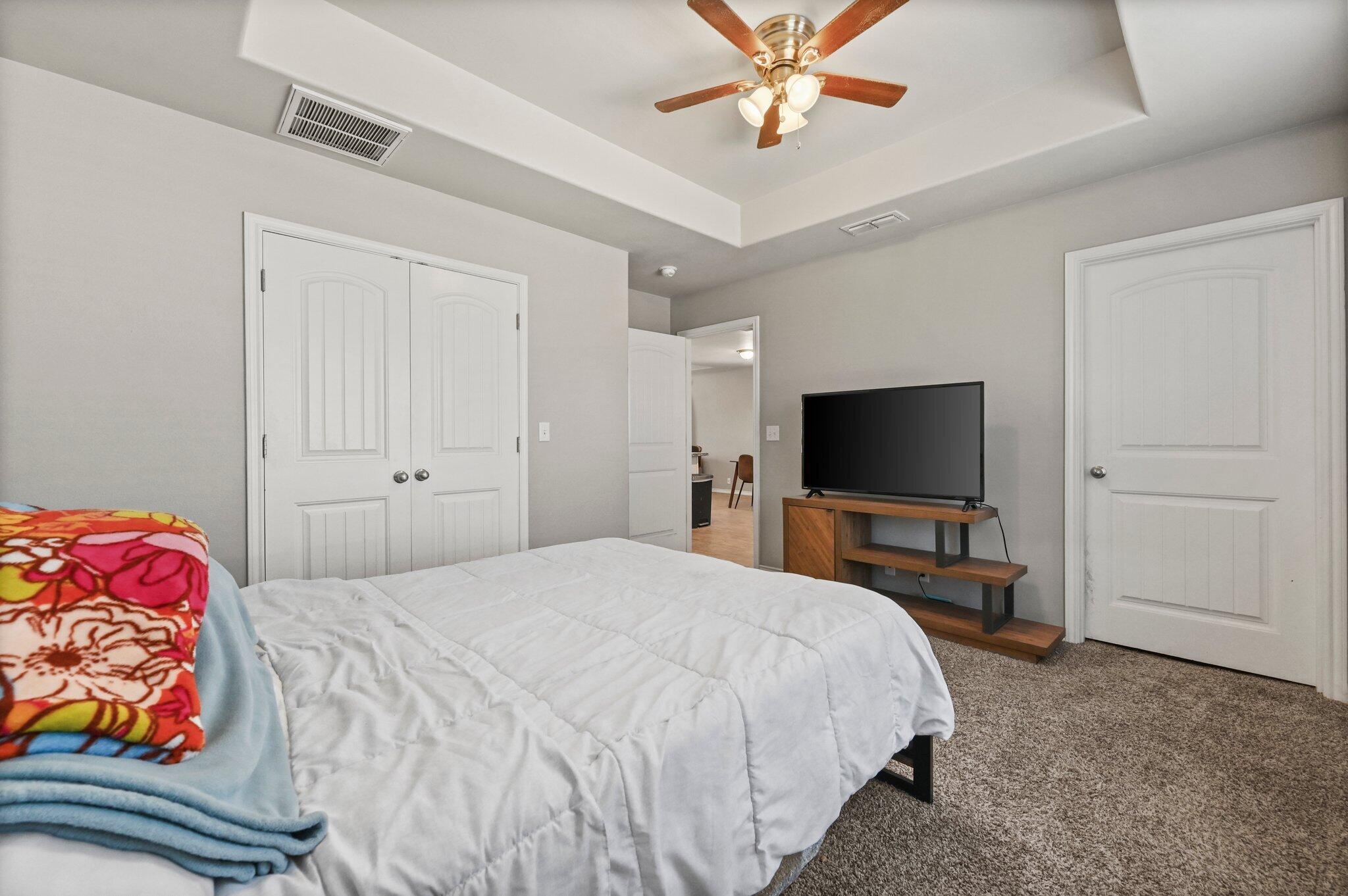 2116 24th Street, Unit 1 Lubbock, TX 79411 - Photo 7 of 13 a bedroom with a bed and a flat screen tv