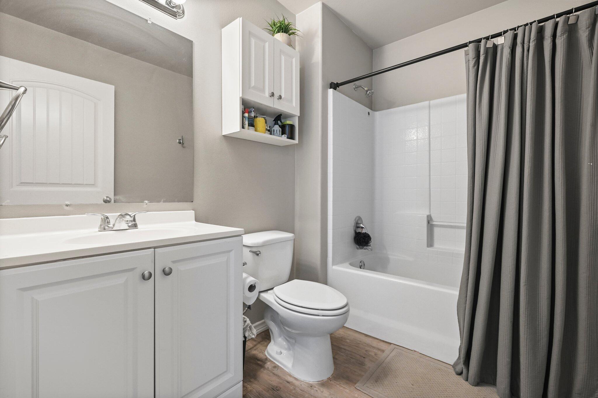 2116 24th Street, Unit 1 Lubbock, TX 79411 - Photo 8 of 13 a bathroom with a sink toilet and shower