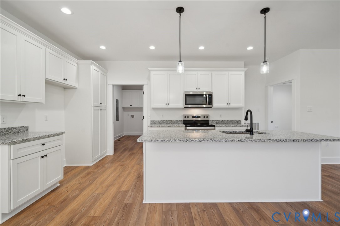 Lot 1 Oak Hill Road Cumberland, VA 23040 - Photo 11 of 26 a large kitchen with stainless steel appliances kitchen island granite countertop a stove a sink a refrigerator and white cabinets with wooden floor