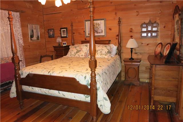 5323 Wiley Hollow Road Culleoka, TN 38451 - Photo 8 of 20 Master bedroom. Natural log walls and hardwood floors.