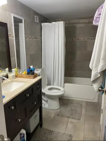a bathroom with a double vanity sink toilet and shower