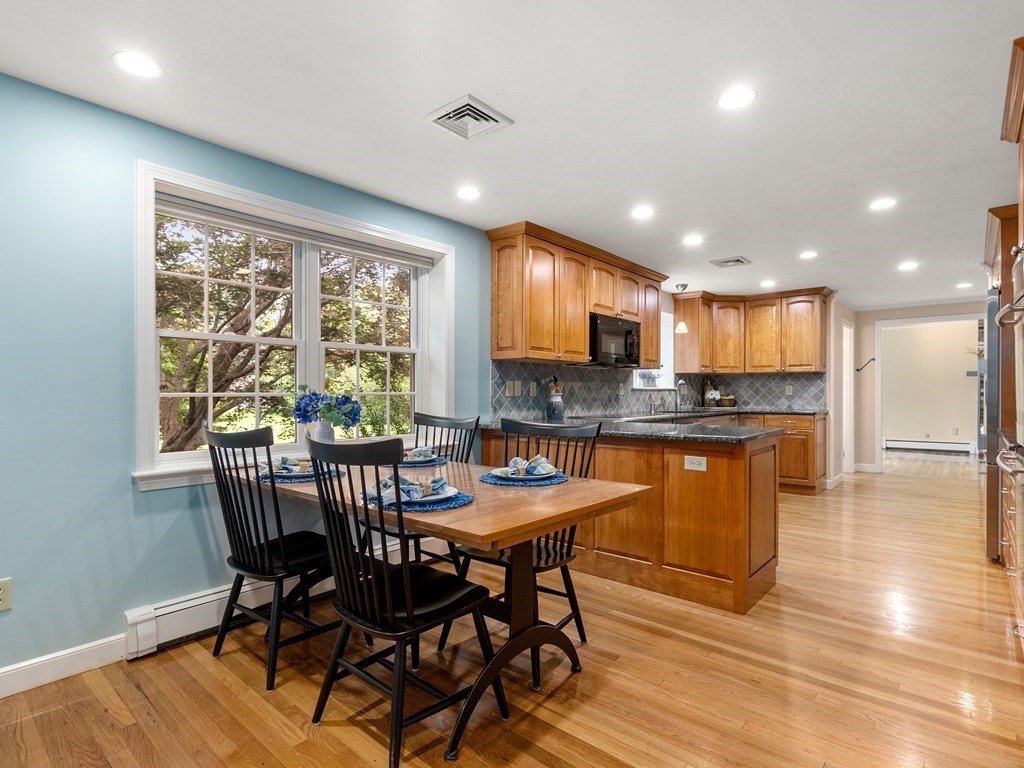 123 Victoria Road Sudbury, MA 01776 - Photo 15 of 42 a kitchen with stainless steel appliances granite countertop dining table chairs refrigerator and sink