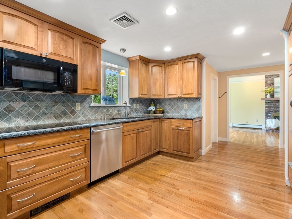 123 Victoria Road Sudbury, MA 01776 - Photo 10 of 42 a kitchen with stainless steel appliances kitchen island granite countertop a stove a sink and a microwave