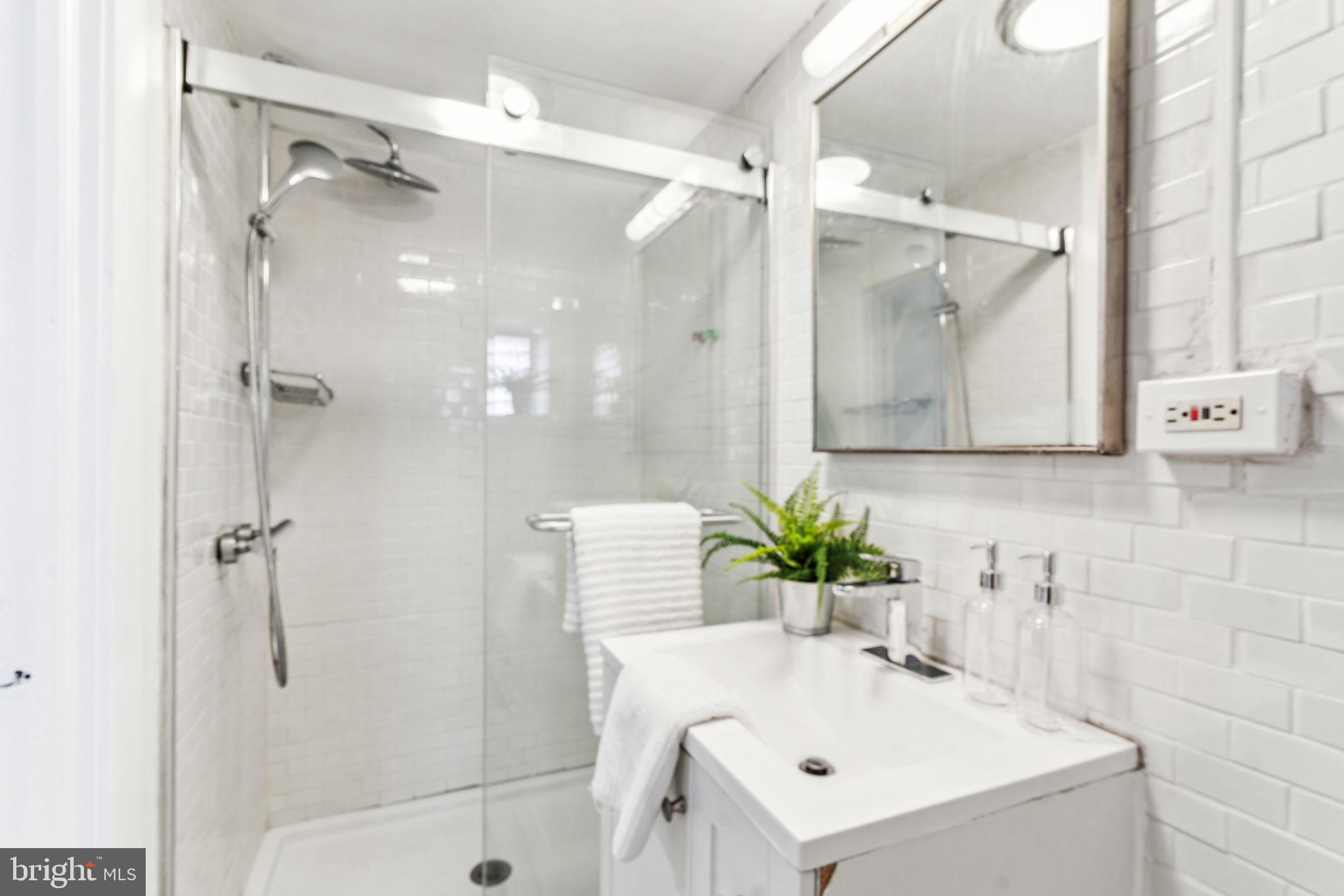 1314 South Warnock Street Philadelphia, PA 19147 - Photo 19 of 24 a bathroom with a sink mirror and shower