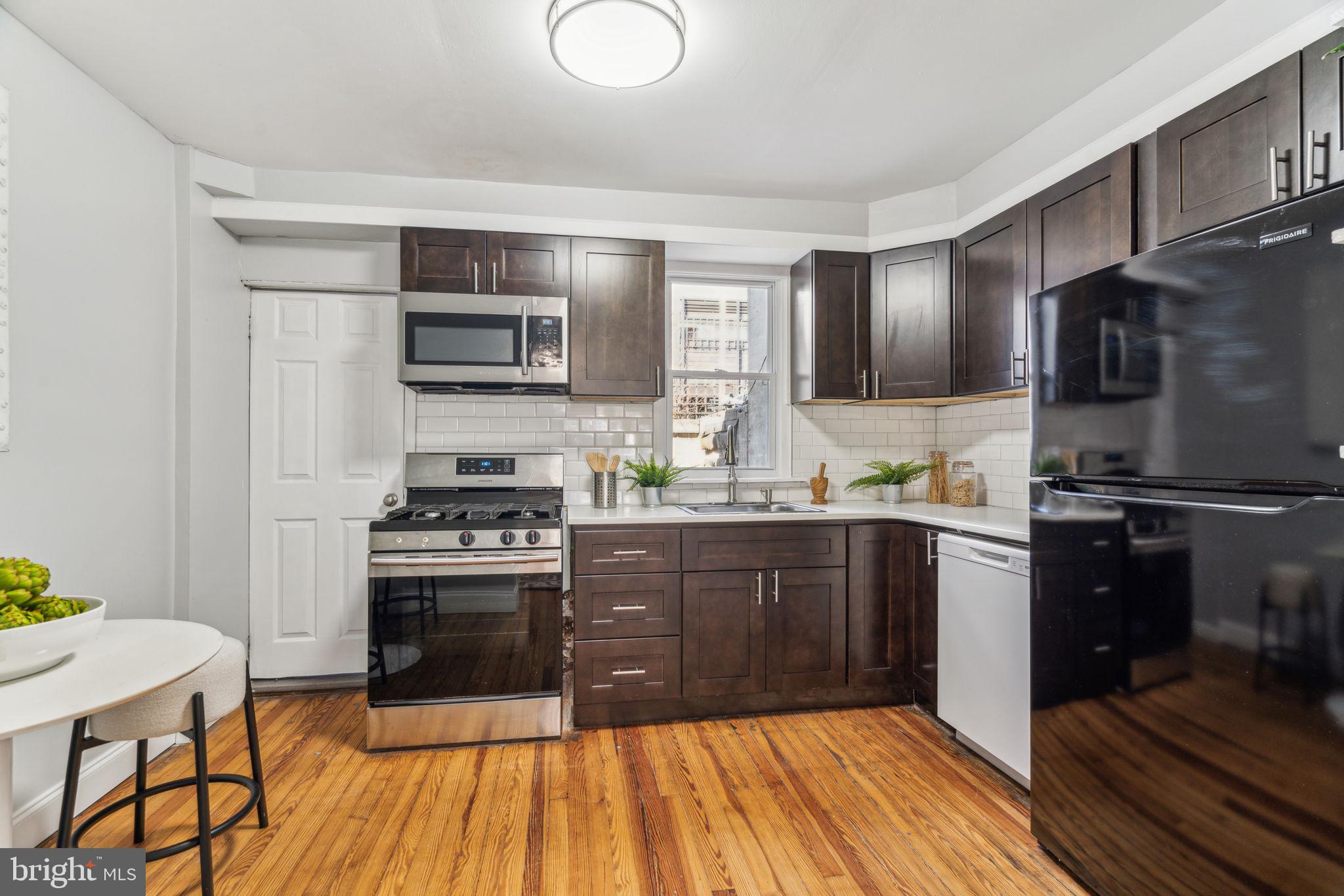 1314 South Warnock Street Philadelphia, PA 19147 - Photo 6 of 24 a kitchen with granite countertop a stove top oven and sink