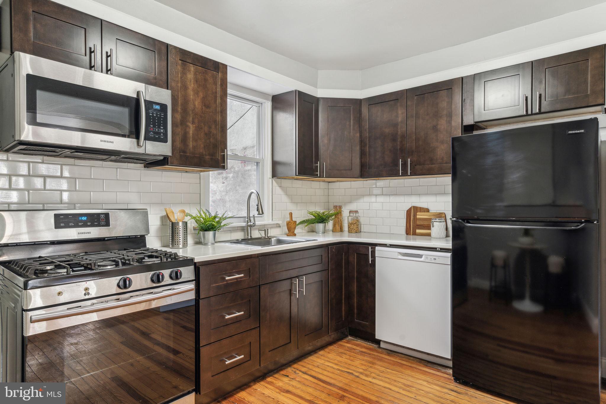 1314 South Warnock Street Philadelphia, PA 19147 - Photo 7 of 24 a kitchen with stainless steel appliances granite countertop a stove a refrigerator and a microwave