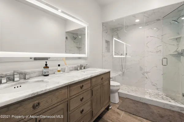 a bathroom with a double vanity sink toilet mirror and bathtub