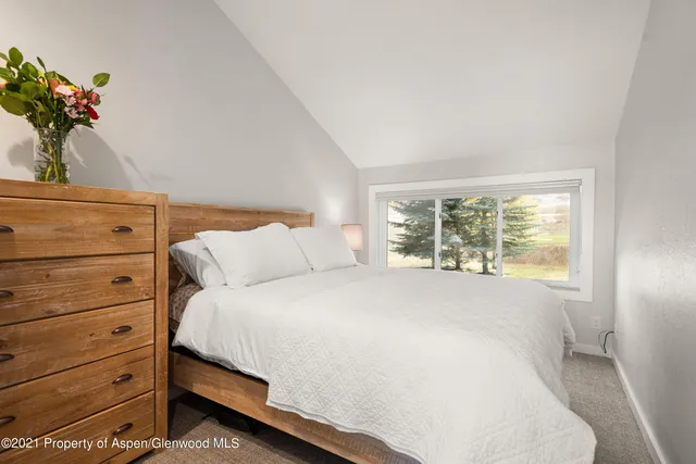 a bedroom with a bed and a potted plant