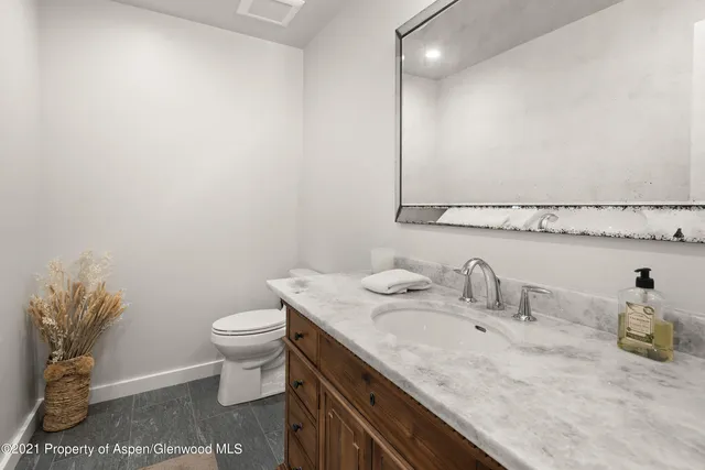 a bathroom with a granite countertop sink a toilet and a mirror