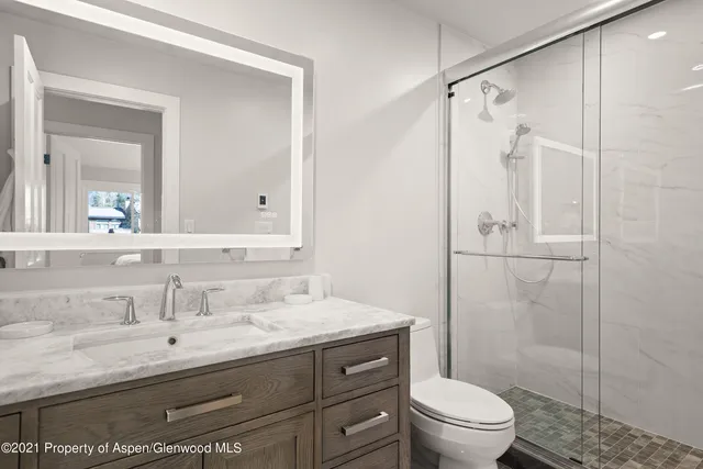 a bathroom with a granite countertop sink toilet and shower