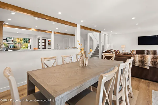 a kitchen with stainless steel appliances granite countertop a stove a table and chairs with wooden floor