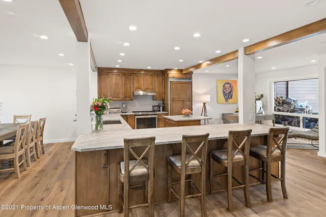 a dining room with stainless steel appliances kitchen island a table and chairs