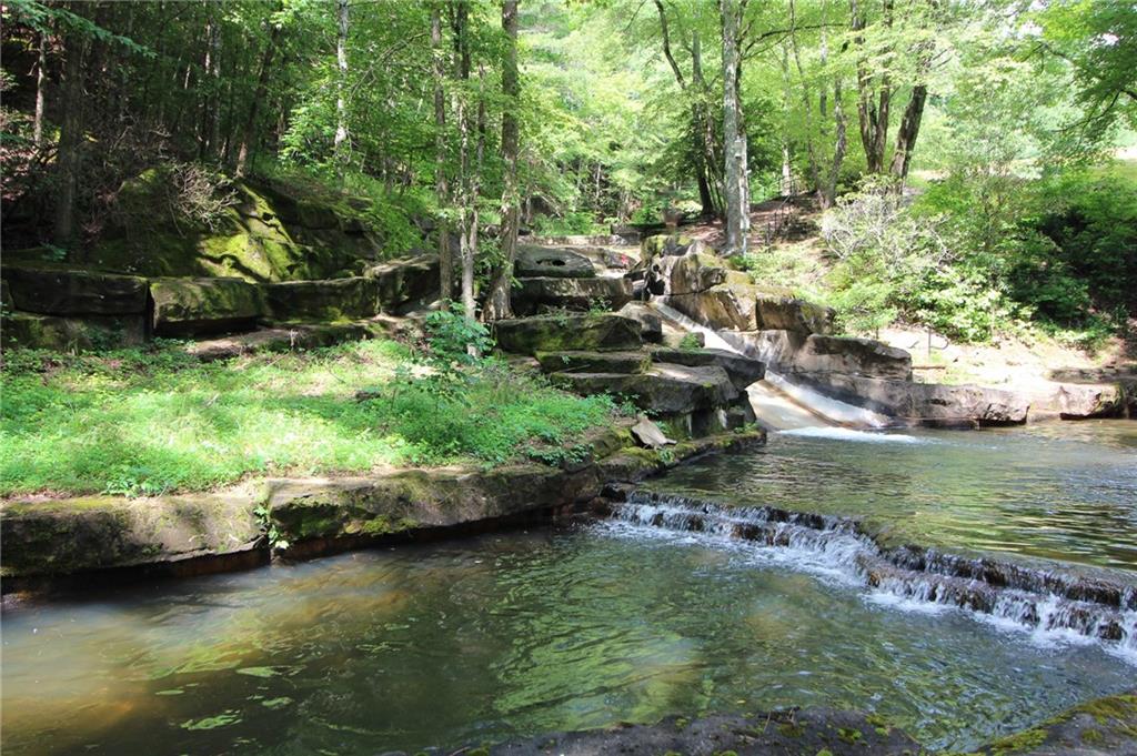 8088 Ridgeview Drive Big Canoe, GA 30143 - Photo 19 of 30 a view of a lake with lawn chairs and large trees