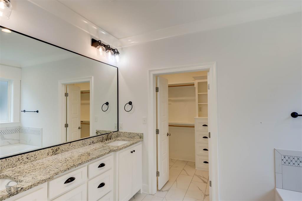 605 Meridian Way Benton, LA 71006 - Photo 24 of 29 Spacious bathroom featuring a dual vanity with light-toned stone countertops, undermount sinks, and white cabinetry