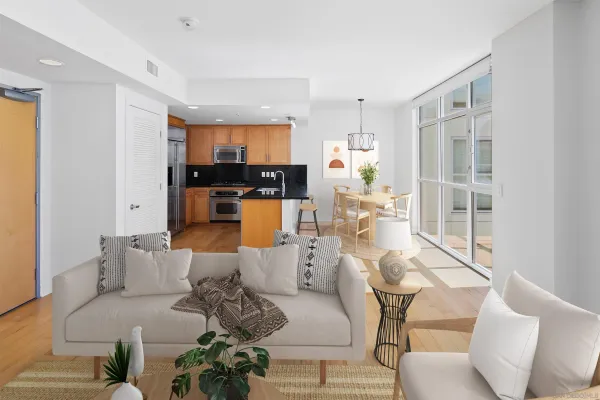 a living room with furniture large window and kitchen view