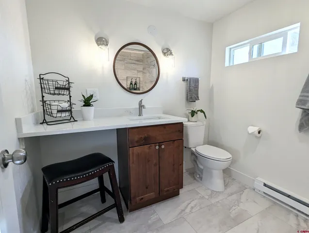 a bathroom with a toilet a sink and a mirror