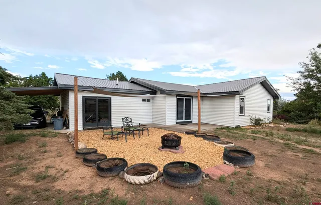 a view of a house with backyard and sitting area