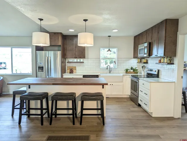 a kitchen with a table chairs refrigerator and microwave