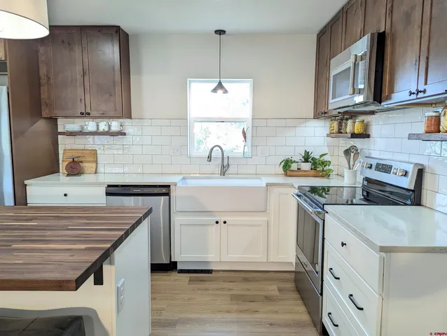 a kitchen with stainless steel appliances granite countertop a sink stove and cabinets