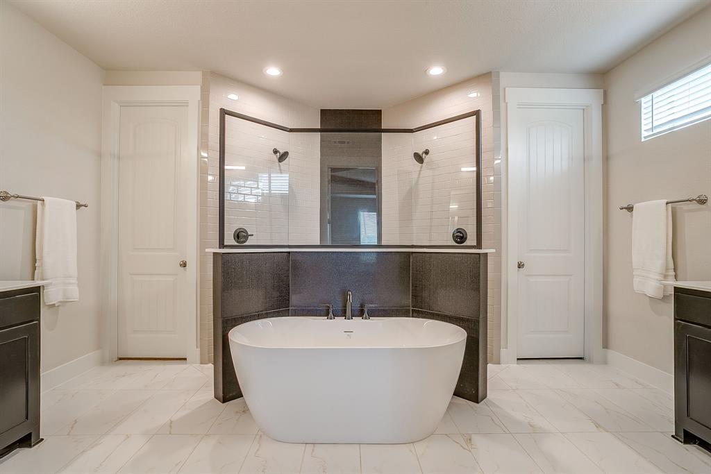 4511 Matador Rnch Road Waxahachie, TX 75165 - Photo 18 of 36 Freestanding soaking tub, dual showers with black hardware, white subway tile shower surrounds, white marble-look flooring, and recessed lighting