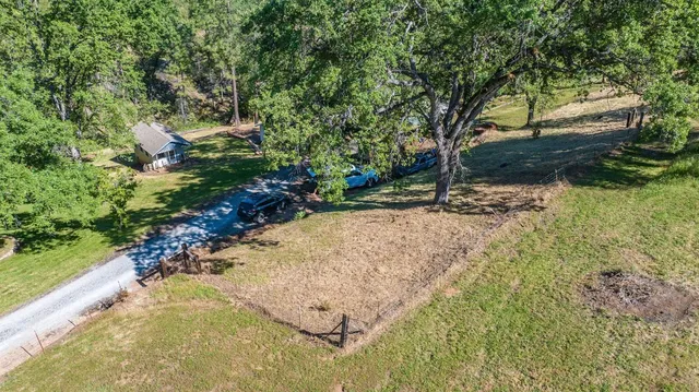 an aerial view of a residential houses with yard