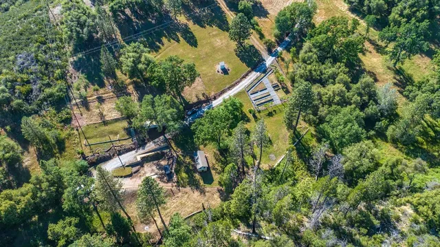 an aerial view of a residential houses with yard