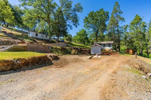 a view of a backyard with lawn chairs and a fire pit