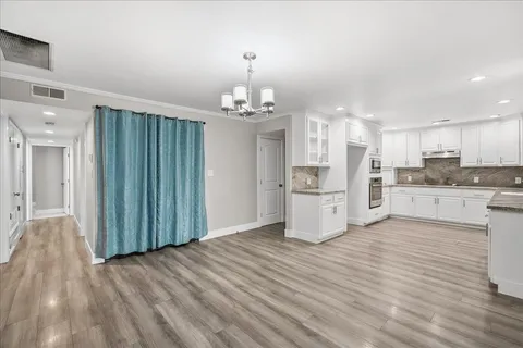 a view of a kitchen with cabinets and wooden floor