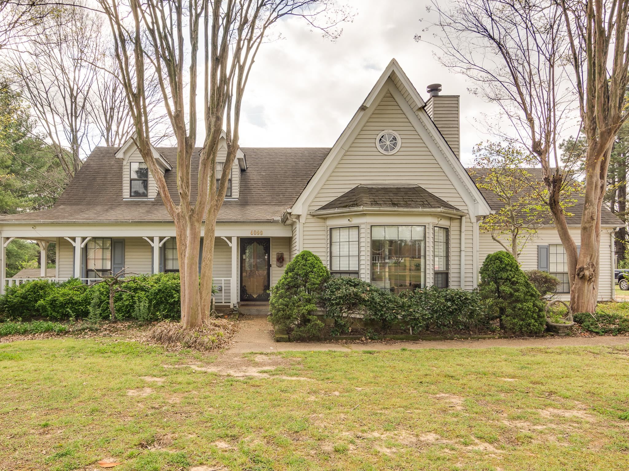 4099 Soderlund Cove Millington, TN 38053 - Photo 1 of 26 View of front of home featuring a front lawn, a porch, roof with shingles, and a chimney