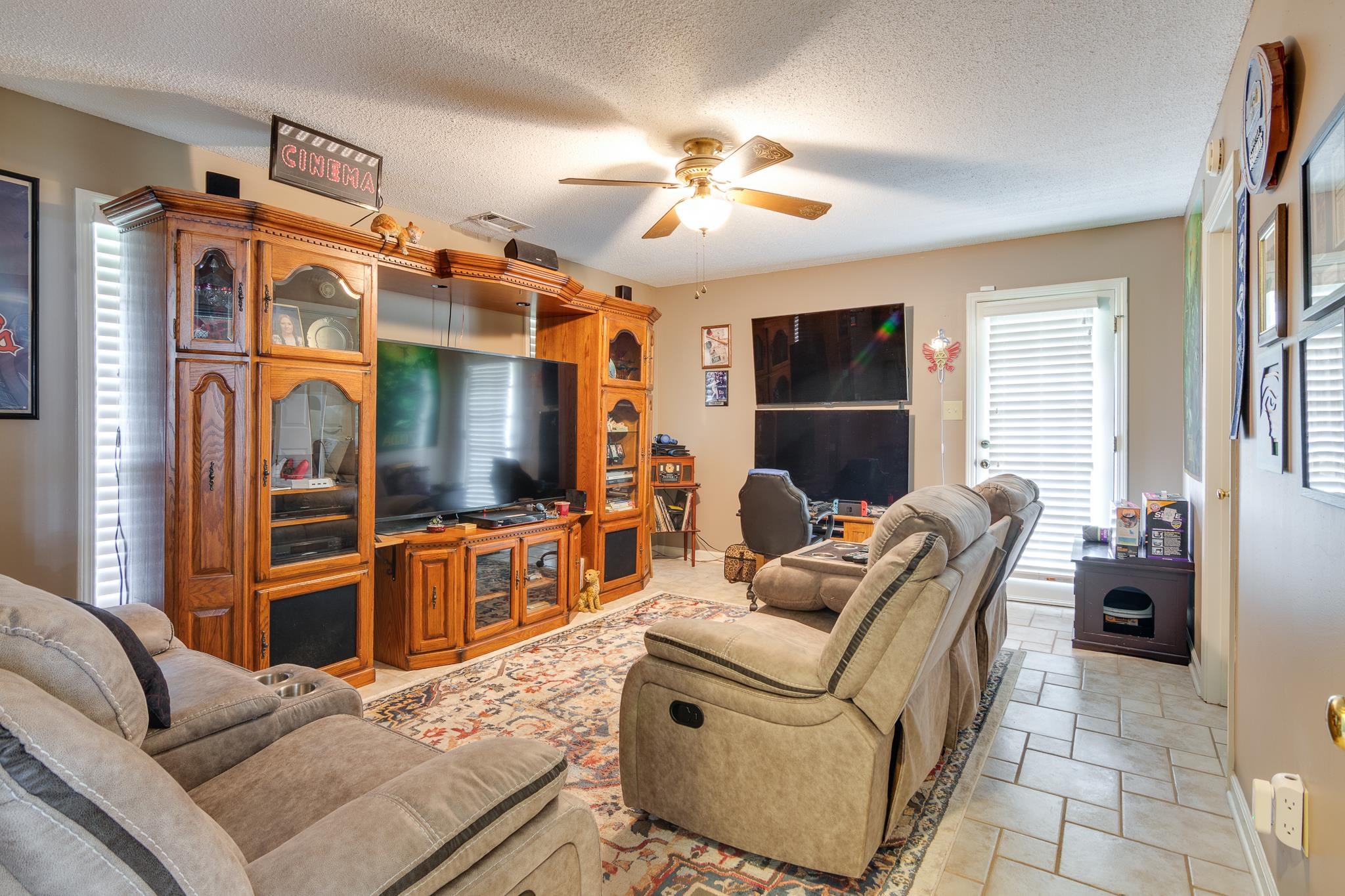 4099 Soderlund Cove Millington, TN 38053 - Photo 12 of 26 Living room featuring ceiling fan, a textured ceiling, and stone tile flooring