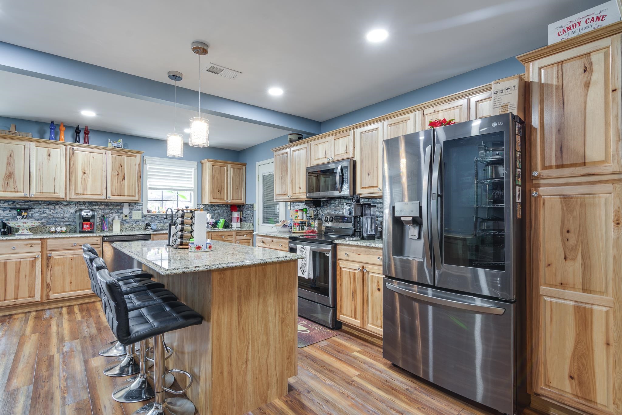 4099 Soderlund Cove Millington, TN 38053 - Photo 7 of 26 Kitchen with stainless steel appliances, a center island, light wood finish cabinetry, backsplash, and light wood-style floors