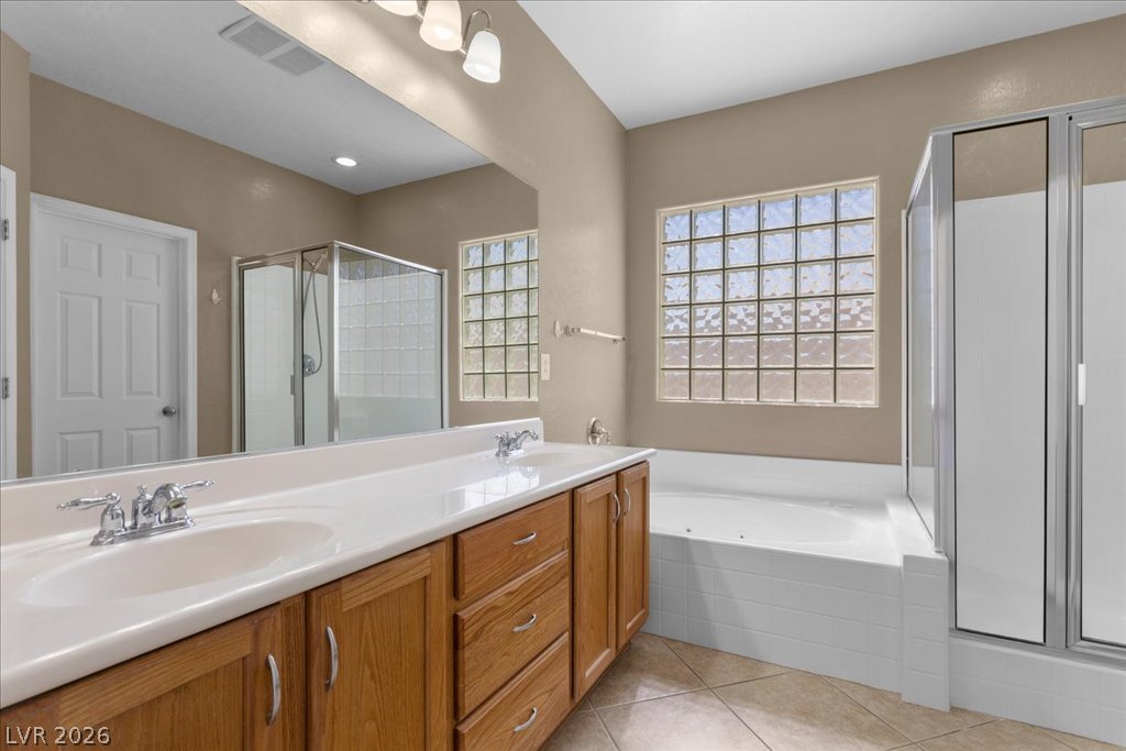 2627 Dirleton Place Henderson, NV 89044 - Photo 23 of 42 Indulge in a primary bathroom featuring a spacious dual vanity, separate glass-enclosed shower, and a Jucuzzi tub.
