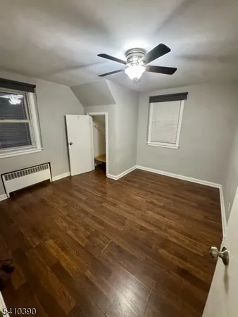 a view of an empty room with window and chandelier fan