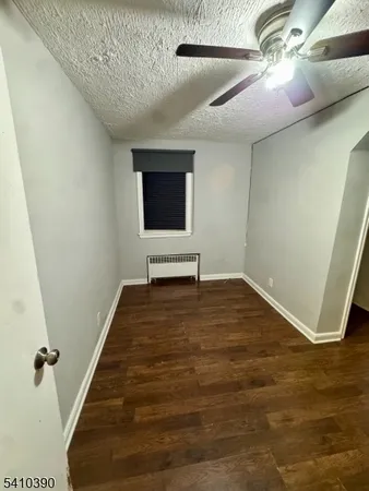 a view of a livingroom with wooden floor and a ceiling fan